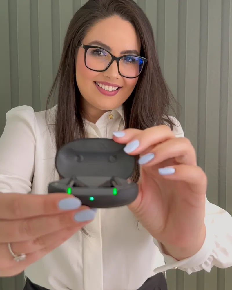 Especialista apresentando aparelho auditivo na AudioTao