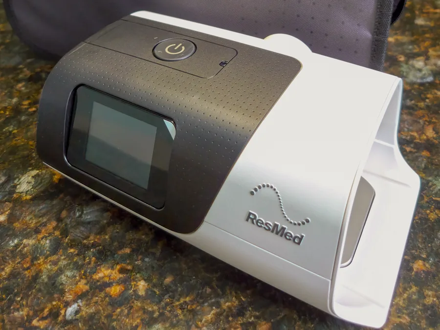 CPAP ResMed AirSense 11 sobre a bancada, ao lado da bolsa de transporte